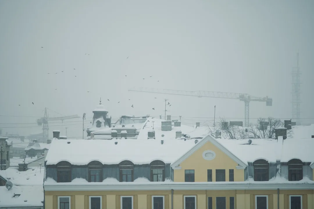 a snow covered roof with a building in the background